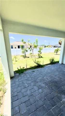 Covered patio area featuring gray paver flooring
