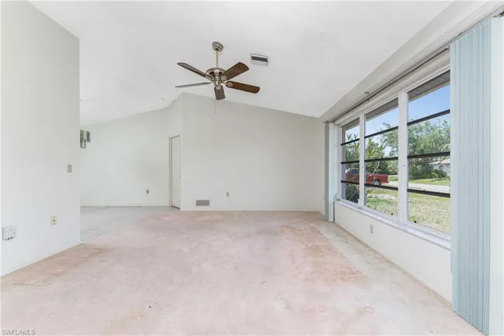 Tiled foyer entrance featuring ceiling fan and vaulted ceiling