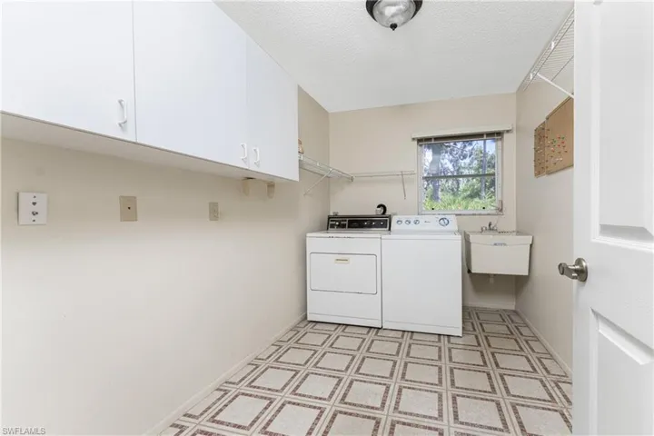 Tiled empty room featuring a chandelier