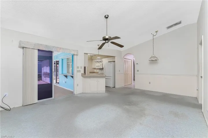 Spare room featuring vaulted ceiling, ceiling fan, and dark hardwood / wood-style floors