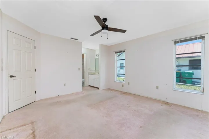 Kitchen featuring dark wood-type flooring, ceiling fan with notable chandelier, a tray ceiling, appliances with stainless steel finishes, and sink