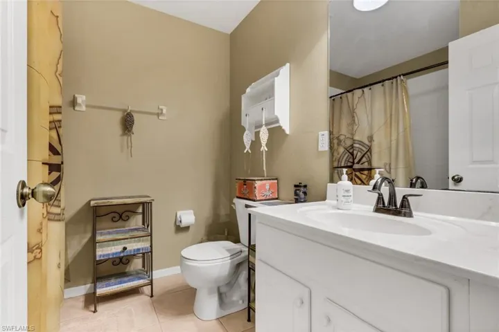 Bathroom featuring a white vanity with an integrated sink, dark bronze-finish faucet, and a large wall-mounted mirror