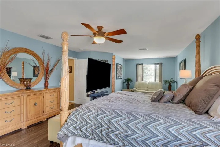 Spacious bedroom featuring wood-finish flooring and a ceiling fan