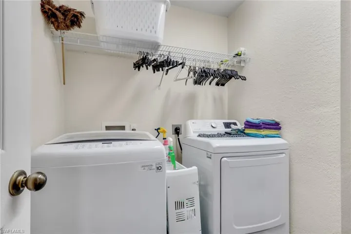 Dedicated laundry area featuring a white top-load washing machine and front-load dryer