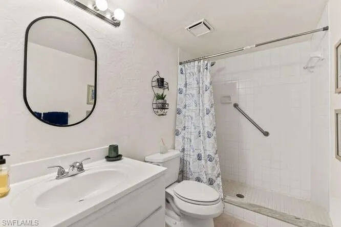 Full bath with a shower stall and vanity