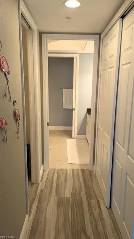 Hall with baseboards and light wood-style floors