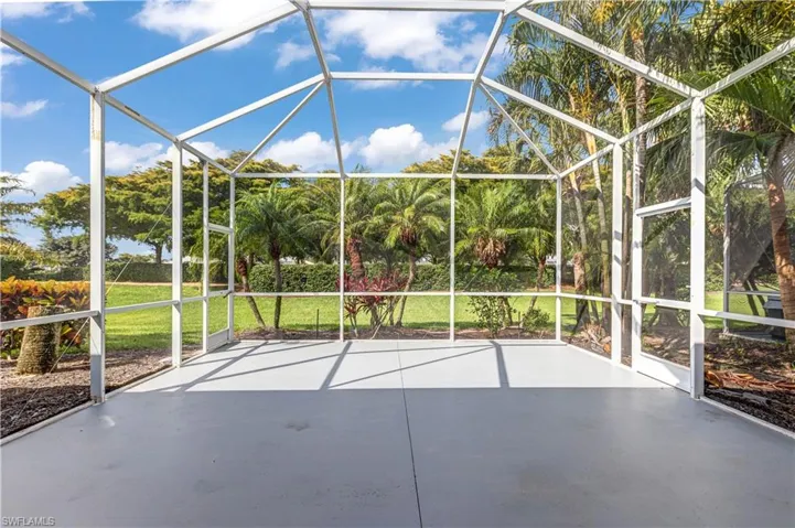 View of patio / terrace featuring a lanai and view of wooded area