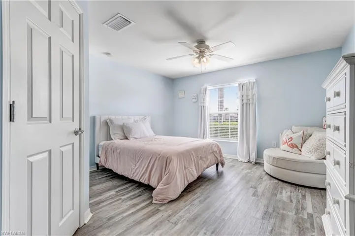 Bedroom featuring light wood-style floors, baseboards, and ceiling fan
