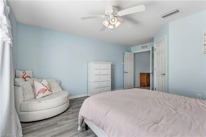 Bedroom featuring wood finished floors, baseboards, and ceiling fan
