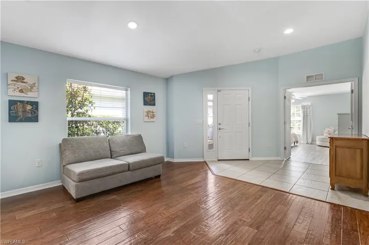 Living area featuring hardwood / wood-style flooring, healthy amount of natural light, baseboards, and recessed lighting