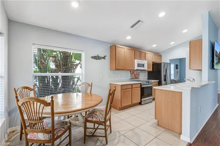 Kitchen featuring stainless steel appliances, a sink, baseboards, light countertops, and a peninsula