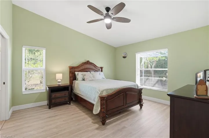 Bedroom featuring light wood-style floors, ceiling fan, and vaulted ceiling
