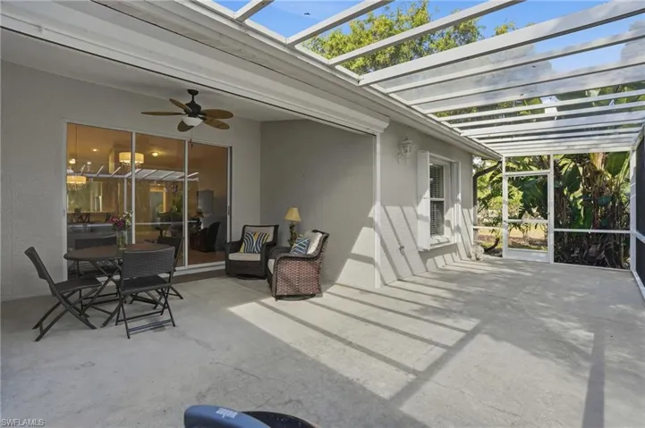View of patio with ceiling fan, a sunroom, a pergola, and glass enclosure