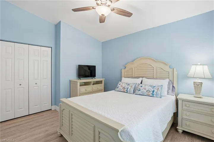 Bedroom featuring a closet, light wood-type flooring, ceiling fan, and lofted ceiling