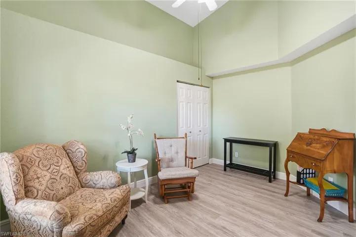 Living area with wood finished floors, a high ceiling, and a ceiling fan