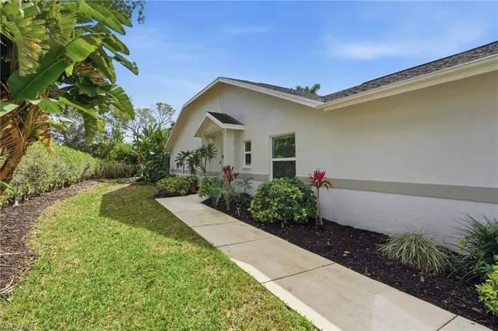 Property entrance with a lawn and stucco siding