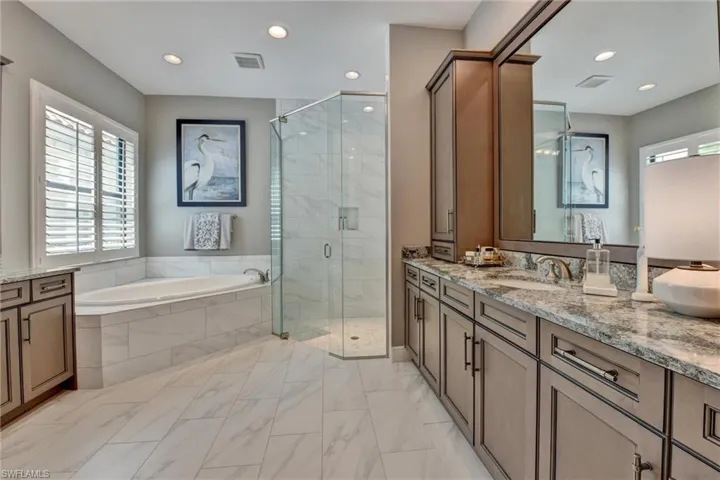 Master Bathroom with tile floors, independent shower and bath, and dual sinks