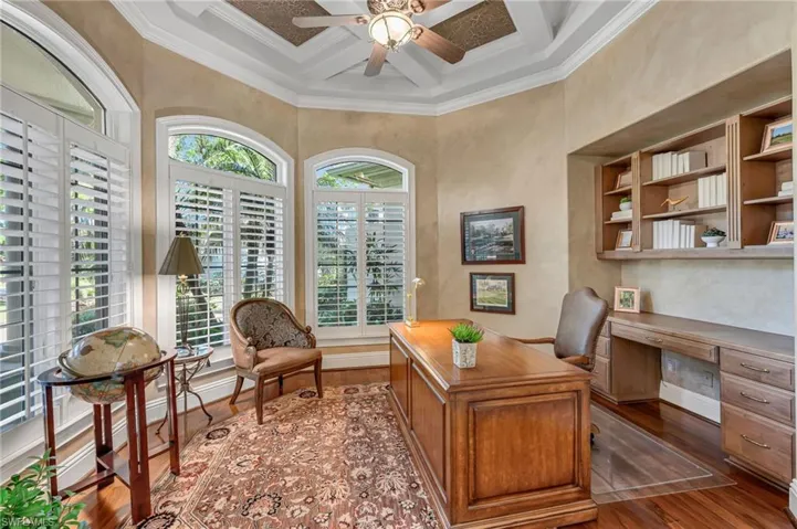 The office has cherry wood floors, coffered ceiling details, generous crown molding, and built-ins, for plenty of storage.