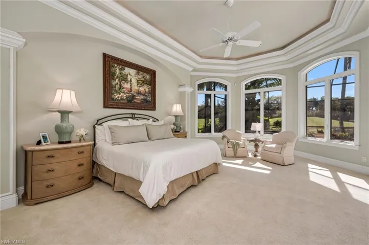 The Primary Suite is large, with detailed, lit, tray ceiling detail, a sitting area, and beautiful views to the outdoors.