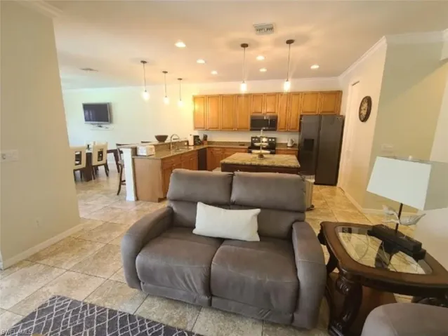 Living room featuring ornamental molding and light tile patterned flooring