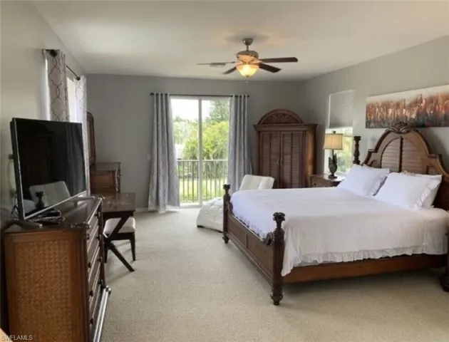 Carpeted bedroom featuring ceiling fan and access to outside
