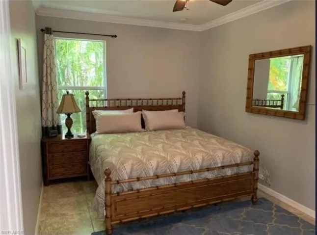 Bedroom featuring ornamental molding, ceiling fan, and tile patterned floors