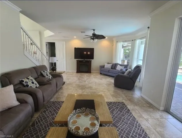 Living room featuring ornamental molding and ceiling fan