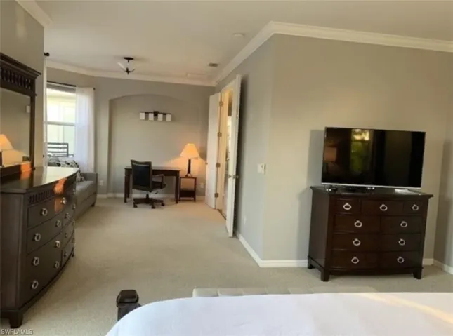 Bedroom featuring crown molding and light carpet