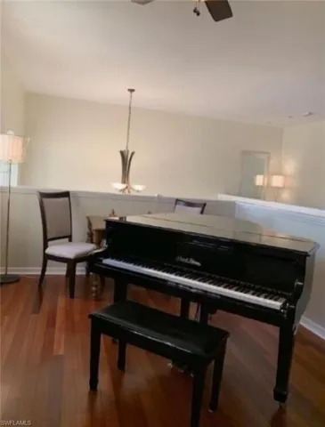 Miscellaneous room featuring ceiling fan with notable chandelier and hardwood / wood-style flooring