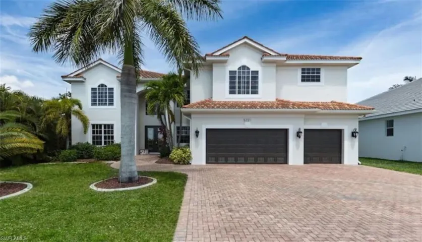Mediterranean / spanish-style house with a garage and a front lawn