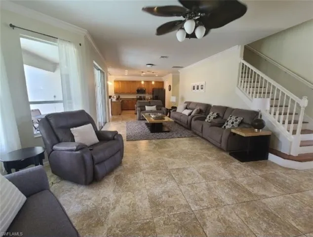 Living room with ceiling fan and crown molding