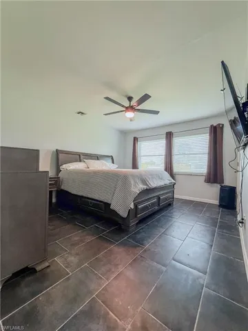 Bedroom with ceiling fan and baseboards