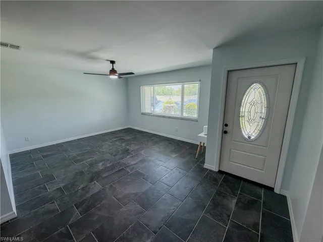 Entryway with ceiling fan and baseboards