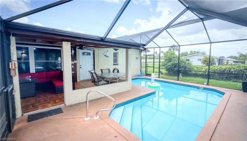Outdoor pool featuring a patio and glass enclosure