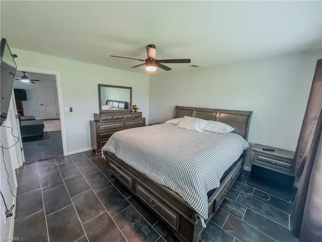 Bedroom with ceiling fan and baseboards