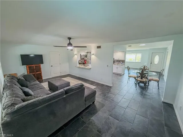 Living area featuring baseboards and ceiling fan