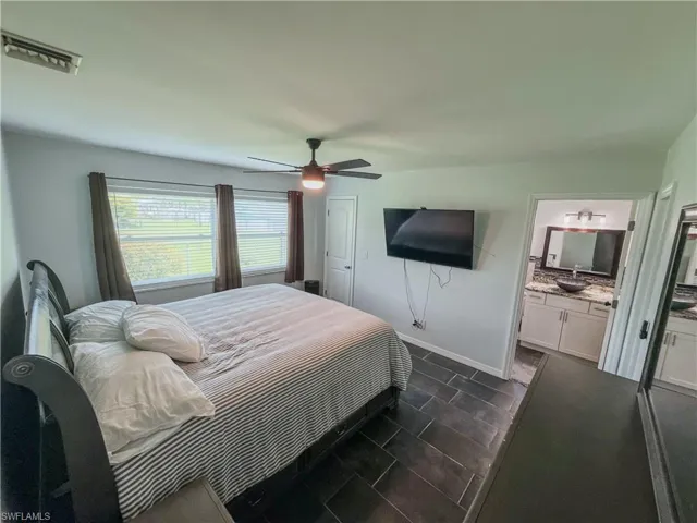 Bedroom with ceiling fan and ensuite bath