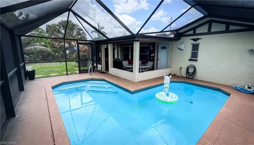 Outdoor pool featuring a patio and glass enclosure