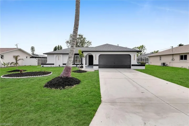 Ranch-style home featuring a garage, a front yard, and cooling unit