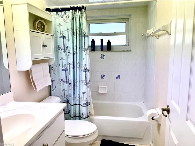 Full bathroom featuring shower / bathtub combination with curtain, vanity, and toilet