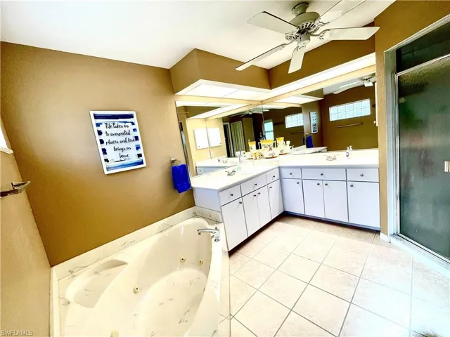 Bathroom featuring tile patterned floors, vanity, and separate shower and tub