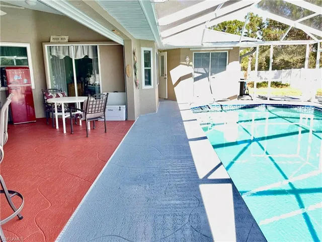 View of pool with a lanai and a patio