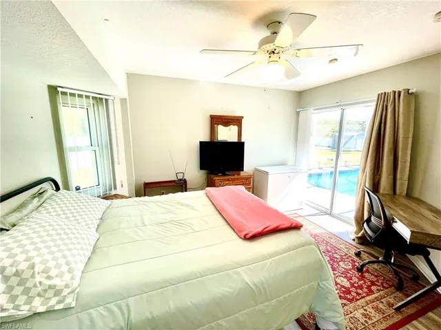 Bedroom featuring access to exterior, a textured ceiling, and ceiling fan