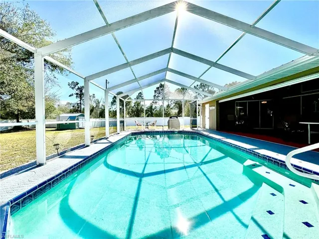 View of swimming pool featuring glass enclosure