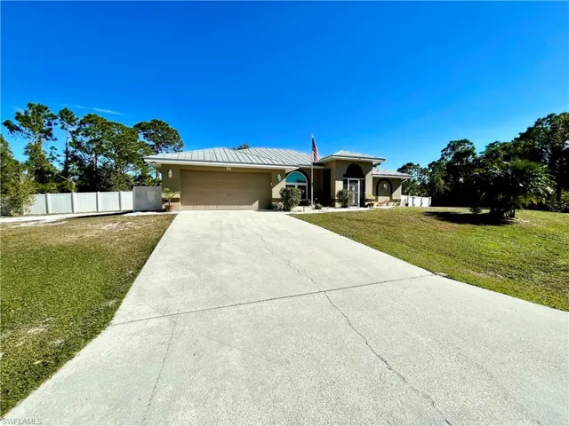 View of front facade featuring a front yard and a garage