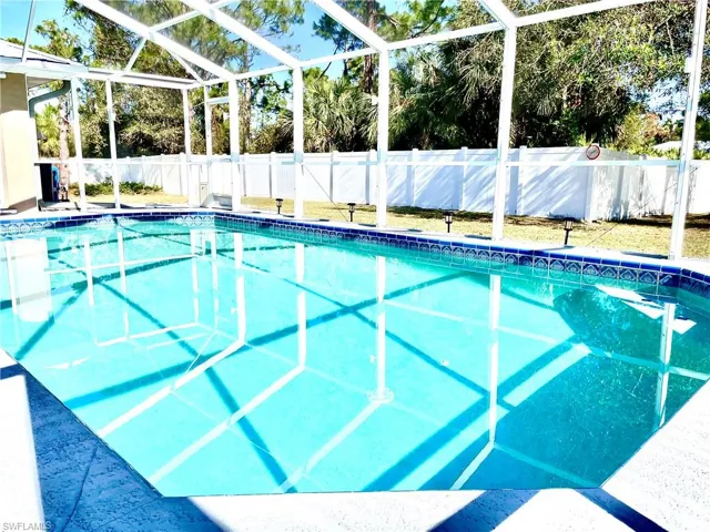 View of swimming pool featuring glass enclosure