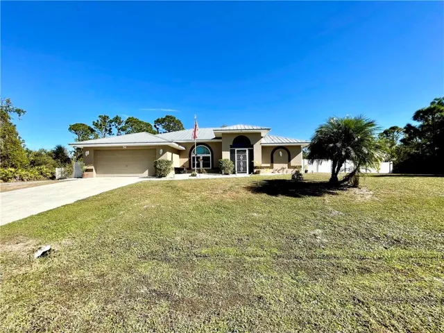 View of front of house featuring a garage and a front lawn