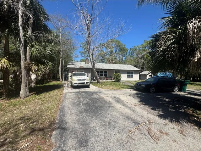 Single story home featuring driveway and a chimney