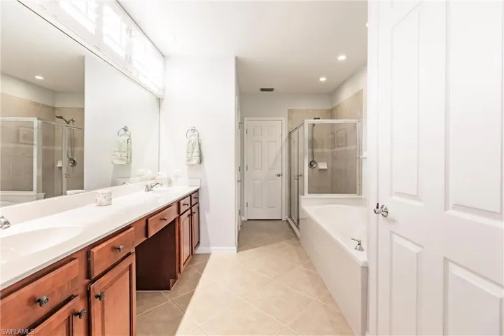 Primary bathroom featuring vanity, separate shower and tub