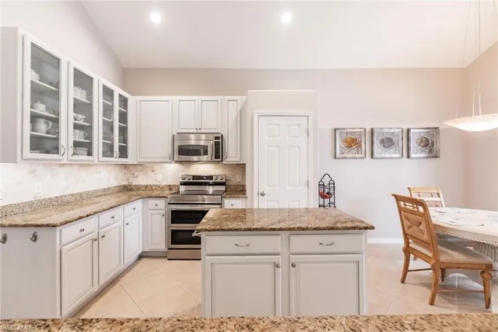 Kitchen with white cabinets, stainless steel appliances, and kitchen island
